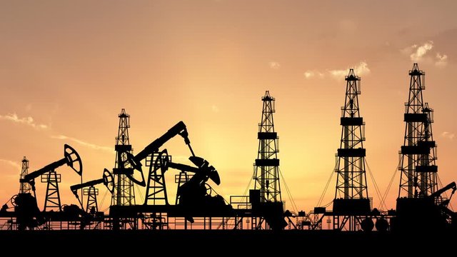 Silhouettes of working oil pumps and oil drilling rigs against the backdrop of the setting sun. Includes alpha matte for composing over footage or another background