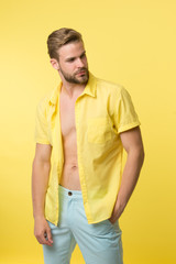 Man calm face posing confidently yellow background. Guy wear unbuttoned shirt with smooth skin on...
