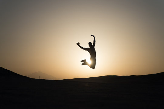 Achieve Main Goal. Silhouette Man Motion Jump In Front Of Sunset Sky Background. Future Success Depends On Your Efforts Now. Daily Motivation. Healthy Lifestyle Personal Achievement Goal And Success