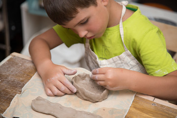 Pottery workshop for kids, raw clay, sculpting tools, glazing and painting clay pots