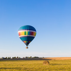 Fototapeta premium Colorful hot-air balloon flying over the forest