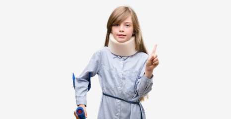 Young blonde child injured wearing neck collar and crutches surprised with an idea or question pointing finger with happy face, number one