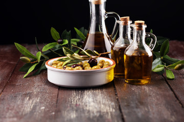 Olives. Bottle virgin olive oil and oil in a bowl with some olives