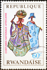 Richly dressed African women on postage stamp of Rwanda