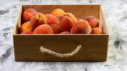 freshly harvested peaches in a wooden crate. On the black table. Free space for text. Top view