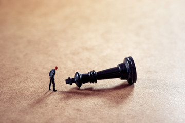 Pensive businessman looking at chess figure