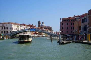 Vaporetto transit boat passing under a bridge - obrazy, fototapety, plakaty