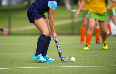 Young hockey player woman with ball in attack playing field hockey game