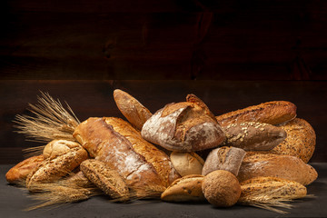 Composition of abundance of freshly baked loaves of bread and buns with ears of wheat - 219196139