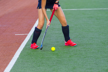 Field hockey player, in possesion of the ball, running over an astroturf pitch, looking for a team...