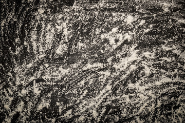 From above of abstract background of black table covered with flour mess