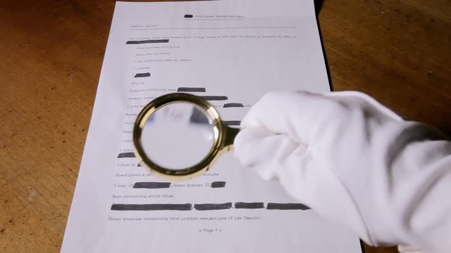 A spy looking at a (fake) secret document with a magnifying lens.
