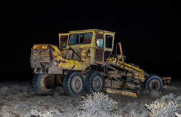 Obraz premium grader in the field at night