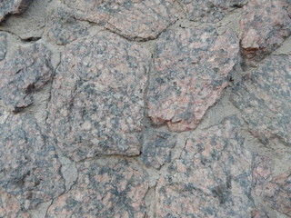 A wall lined with a coarse gray stone