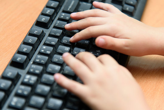 Online education of school children. Children hands on keyboard pc close up.