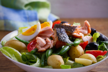 Salad Nicoise with salmon. Tomato, green beans, new potato, olives and lettuce salad with salmon. horizontal