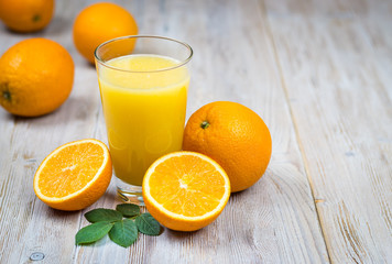 Orange juice and citrus fruits on rustic wooden table with copy space