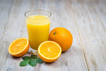 Orange juice and citrus fruits on rustic wooden table with copy space
