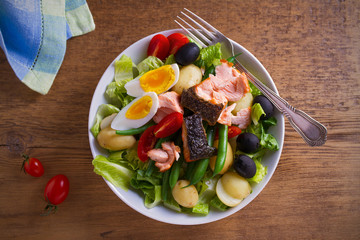 Salad Nicoise with salmon. Tomato, green beans, new potato, olives and lettuce salad with salmon. overhead, horizontal