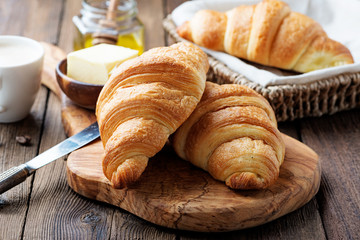 Delicious breakfast with fresh croissants and coffee served with butter and honey. - 219200550