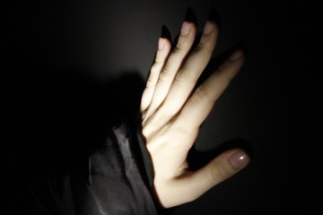 Hand against black wall