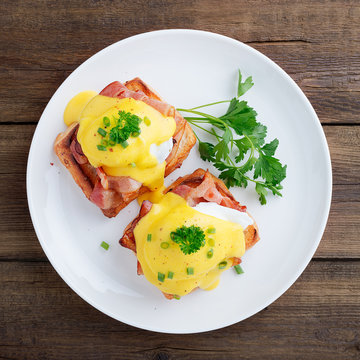 Eggs Benedict With Bacon On Wooden Background . Top View 