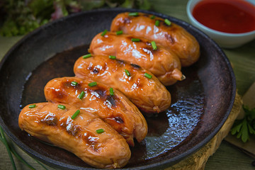 Fried sauseges with green onions and tomato souce.