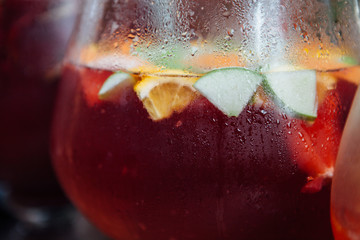 A sweaty glass of sangria with pieces of apple and orange