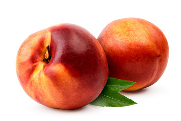 Two nectarines with leaves close-up on a white background.