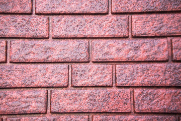 Artificial finishing material, imitating a red brick wall, close up.