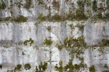 Close-up of rough texture of aged gray concrete wall with geometric pattern relief, with dirty flow marks.