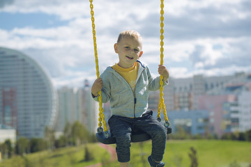 A boy is riding a swing