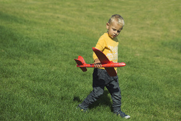 boy playing with a red airplane