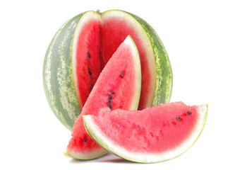 A large ripe watermelon next to watermelon slices on a white isolated background