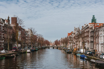 Fototapeta premium Houses and Boats along a Canal in Downtown Amsterdam, the Netherlands