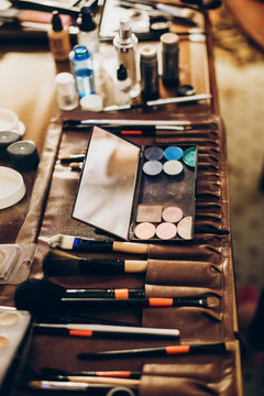 brushes and eyeshadows palette. makeup set of brushes, powder, eyeshadows on table. artist making gorgeous make-up for bride in the morning. beauty and fashion image