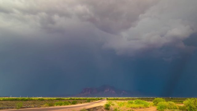 A beautiful transition of changing scene/light/mood/weather. Time lapse of stormy clouds over the Superstition mountains Arizona