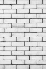 texture of a wall from a natural white brick with small cracks and chips, close-up abstract background