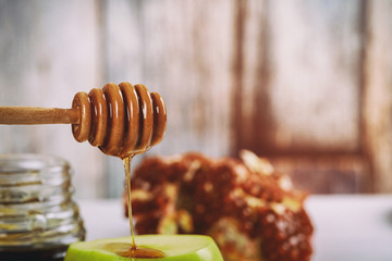 rosh hashanah jewesh holiday concept - shofar, torah book, honey, apple and pomegranate over wooden table. a kippah a yamolka