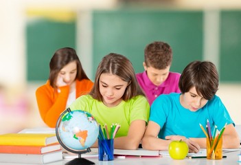 Friendly school children on blurred classroom background