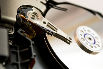 Computer hard drive opened up, showing the two disks and the needle inside and the blurred background.