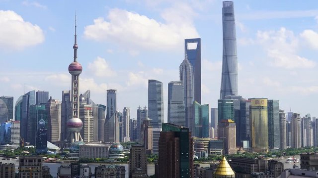 Shanghai Lujiazui business district in summer. Chinese city downtown with beautiful clear day with white fluffy clouds. Cityscape of Pudong in urban China in daytime.