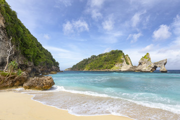 Beautiful afternoon view of an amazing arch on a small island just off of Atuh Beach in Nusa Penida.