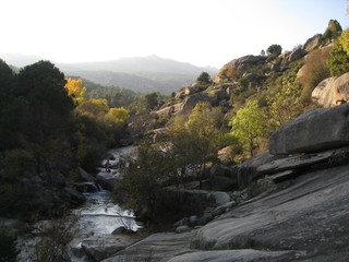 Río en valle entre montañas y bosque en otoño