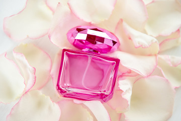 pink perfume bottle against a background of tender rose petals