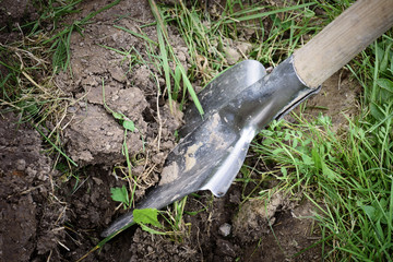 Soil with shovel in garden