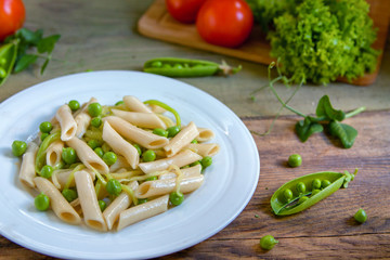 Penne pasta with green peas, zucchini noodle  and herbs
