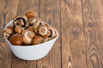 White ceramic bowl filled with fresh mushrooms