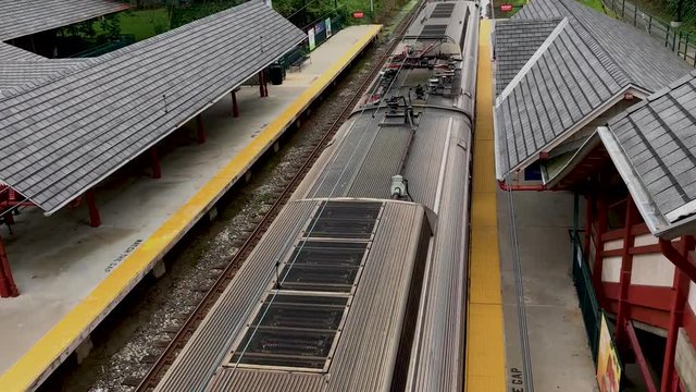 Septa train is leavinga  train station, view from above and back, one passenger leaving train station.