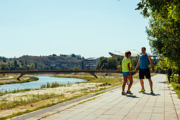 Couple prepare to running on riverside. Working out in the city urban area.